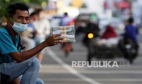 Penjual jasa penukaran uang menawarkan uang baru di kawasan Diponegoro, Padang, Sumatera Barat, Senin (3/5/2021). Penjual jasa tersebut memungut tambahan biaya lima sampai 10 persen dari jumlah uang yang ditukarkan untuk uang kertas pecahan Rp2.000, Rp5.000, Rp10.000, Rp20.000. 