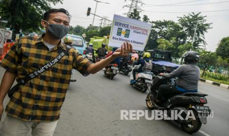 Penjual jasa servis telepon genggam menawarkan jasanya di kawasan Pusat Grosir Cililitan (PGC), Jakarta, Rabu (13/5/2020). Pembatasan Sosial Berskala Besar (PSBB) menyebabkan para penjual jasa servis telepon genggam di PGC menawarkan jasanya di tepi jalan karena larangan membuka gerai di mal tersebut.