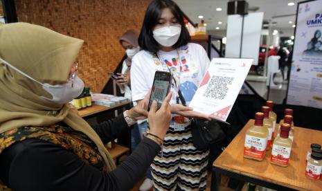 Penjual melayani pembeli melakukan pembayaran digital via QRIS saat pembelian produk UMKM pada pameran Apresiasi Kreasi Indonesia 2022 di Mall Lippo Plaza Sidoarjo, Jawa Timur, Jumat (2/9/2022). Apresiasi Kreasi Indonesia merupakan program pengembangan ekonomi kreatif yang digagas Kemenparekraf melalui peningkatan kapasitas dan pameran bagi para pelaku usaha ekonomi kreatif. 