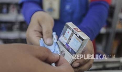 Penjual melayani pembeli rokok di Jakarta, Rabu (19/9).