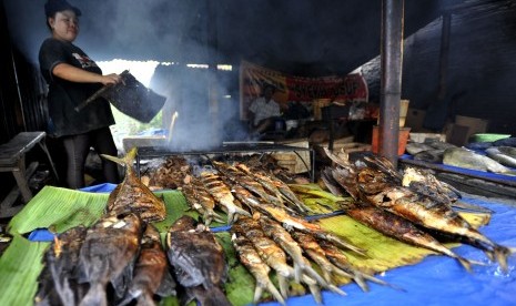 Penjual membakar ikan di Makassar, Sulsel.