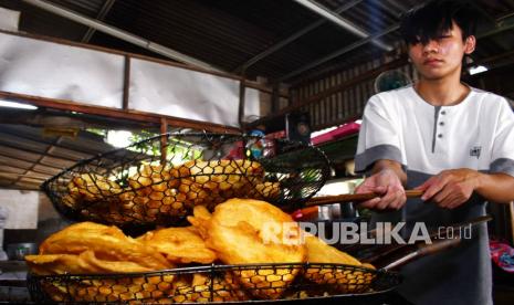 Penjual membuat gorengan di Kota Madiun, Jawa Timur, Senin (17/1/2022). Penjual gorengan terpaksa menaikan harga gorengan dari Rp1.000 per biji menjadi Rp1.250 per biji akibat melonjaknya harga minyak goreng dari Rp14 ribu menjadi Rp20 ribu per kilogram. 