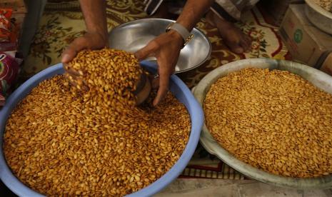 Penjual menakar pumpkin seeds. Biji labu memiliki banyak khasiat bagi kesehatan, salah satunya membantu mengelola glukosa darah..   