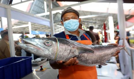 Penjual menunjukan ikan tengiri yang dijualnya pada acara Fish Market Festival 2022 di Kampung Mandar, Banyuwangi, Jawa Timur, Senin (8/8/2022). Festival yang dikemas dengan bazar umkm produk perikanan, pelatihan kuliner dan pagelaran budaya itu sebagai upaya mengangkat potensi perikanan Banyuwangi dan mengenalkan kampung Mandar sebagai pusat kuliner makanan laut.