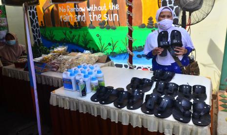 Penjual menunjukkan produk sandal pada pembukaan Gelaran Dagangan Rakyat (Geldara) di Desa Janggalan, Kudus, Jawa Tengah, Rabu (10/11/2021). Kegiatan yang digelar pemerintah desa yang menghadirkan produk karya warga setempat berupa kerajinan, kuliner, hingga pakaian itu sebagai upaya mendorong bangkitnya UMKM serta pemulihan ekonomi akibat terdampak pandemi.