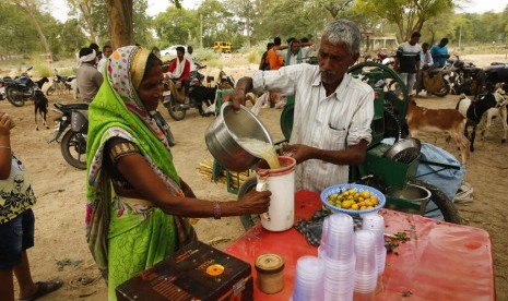 Penjual minuman tebu di hari yang panas di pinggiran Rae Bareli, Uttar Pradesh, India, Rabu (12/6). Suhu udara di utara dan barat India mencapai 48 derajat Celsius. 