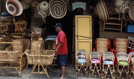 Penjual produk anyaman rotan menata dagangannya di Jakarta, Selasa (29/3).