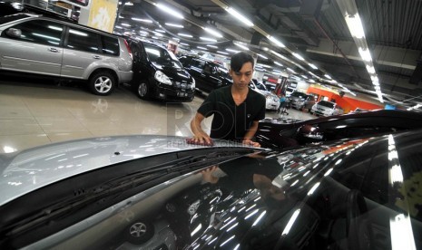 Penjualan Mobi Bekas. Pegawai mengelap mobil yang dipajang salah satu showroom di pusat penjualan mobil bekas Mangga Dua, Jakarta, Rabu (2/7).(Republika/ Wihdan).