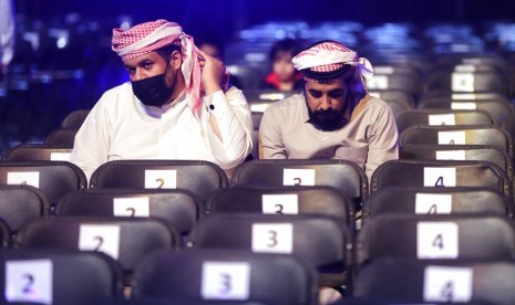 Penonton acara gulat WWE Super Show Down di Riyadh, Arab Saudi memakai masker untuk mencegah penyebaran virus corona, Kamis (27/2).(AP Photo/Amr Nabil)