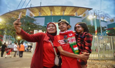 Penonton berswafoto saat akan memasuki area stadion untuk menyaksikan laga Timnas Indonesia melawan Ekuador pada babak penyisihan Piala Dunia U17 di Stadion Gelora Bung Tomo (GBT) Surabaya, Jawa Timur.