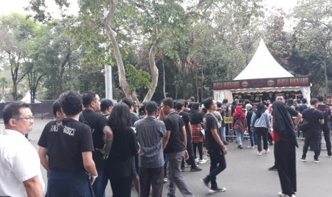 Penonton konser Guns N Roses mengantre masuk ke booth merchandise resmi band asal Amerika yang tampil di konser di Jakarta, Kamis (8/11).