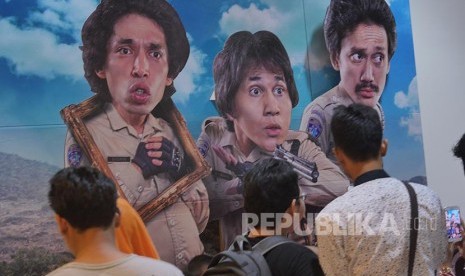 Penonton memperhatikan poster film Warkop DKI Reborn Part 1  pada acara BJB Wide Screen di Bekasi, Sabtu (10/9)