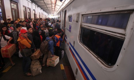 Penumpang antre masuk ke gerbong kereta api di Stasiun Gubeng Surabaya, Jawa Timur.