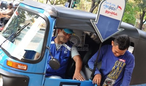 Penumpang bajaj biru turun di Jalan Medan Merdeka Utara, Jakarta Pusat, Selasa (18/8).