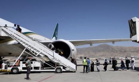 Taliban Tuntut AS Cairkan Aset Afghanistan. FOto: Penumpang berdiri dalam antrian untuk naik pesawat PIA, di bandara Kabul