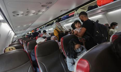 Penumpang berjalan di lorong kabin dalam pesawat di Bandara Tjilik Riwut, Palangka Raya, Kalimantan Tengah, Jumat (13/5/2022). Sisi kiri pesawat biasanya menyediakan lebih banyak ruang sandaran kepala daripada kanan.