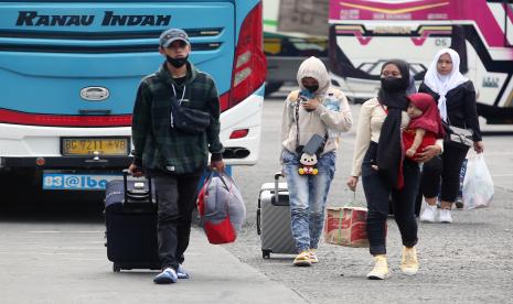 Penumpang berjalan setibanya di Terminal Kalideres, Jakarta.