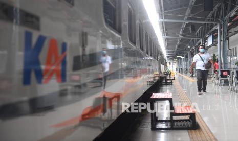 Penumpang bersiap menaiki kereta api di stasiun. 