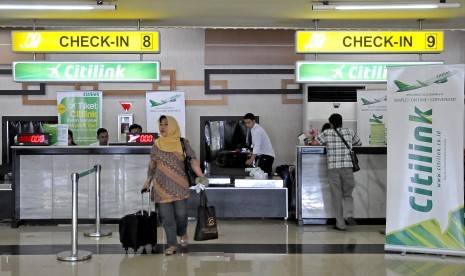 Penumpang Citilink berjalan usai melakukan chek-in di Bandara Halim Perdanakusuma, Jakarta, Ahad (1/6). 