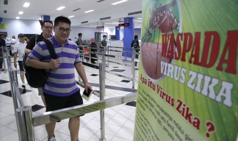 Penumpang kapal ferry dari Singapura melewati poster himbauan kewaspadaan terhadap penyebaran virus Zika di Pelabuhan Internasional Batam Centre, Batam, Kepulauan Riau, Kamis (1/9). 