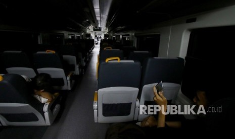 Penumpang kereta bandara memainkan telepon genggamnya saat mengalami gangguan di Stasiun Rawa Buaya, Jakarta, Selasa (5/12).