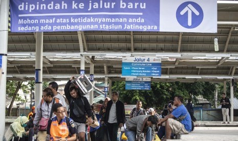 Penumpang kereta beraktivitas di peron jalur rel dwiganda Stasiun Jatinegara, Jakarta, Jumat (12/4/2019).