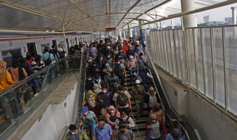 Penumpang KRL Commuter Line menuruni anak tangga setibanya di Stasiun Manggarai, Jakarta.