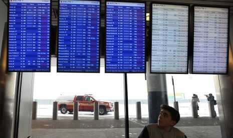 Penumpang melihat jadwal penerbangan di Bandara LaGuardia, New York.