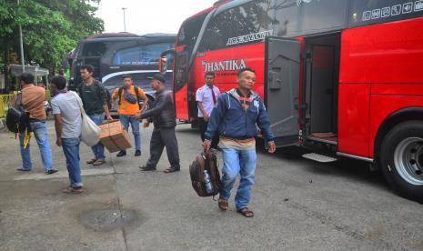 Penumpang membawa barang bawaan usai turun dari bus di Terminal Induk Jati, Kudus, Jawa Tengah, Selasa (26/4/2022). Menurut kepala terminal setempat, memasuki H-6 Hari Raya Idul Fitri 1443 H terminal tersebut mulai ramai pemudik dengan bus yang masuk mencapai 170 bus per hari. 