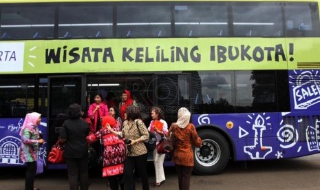 Penumpang menaiki bus wisata saat uji coba dan sosialisasi kepada penumpang di Jakarta, Jumat (21/2). ( Republika/Yasin Habibi)