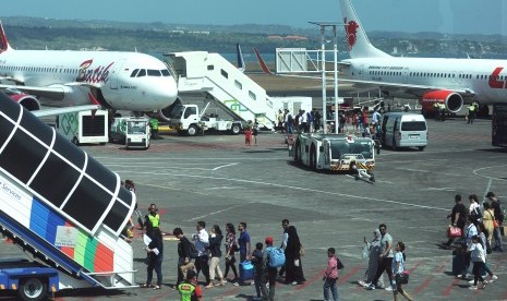 Penumpang menaiki pesawat udara di Bandara Internasional I Gusti Ngurah Rai, Bali.