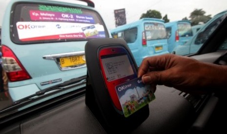 Penumpang menempelkan kartu Ok-Otrip saat menaiki angkutan umum jurusan Kampung Melayu-Duren Sawit di Terminal Kampung Melayu, Jakarta, Senin (15/1). 