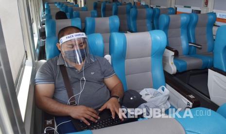 Penumpang mengenakan masker dan pelindung wajah berada di Kereta Api Sancaka relasi Surabaya Yogyakarta saat transit Stasiun KA Madiun, Jawa Timur, Jumat (12/6/2020). PT KAI mulai Jumat (12/6) secara bertahap mengoperasikan kembali KA reguler dengan tetap menerapkan protokol kesehatan pencegahan penyebaran COVID-19, antara lain mengenakan masker, jaket atau baju lengan panjang, pelindung wajah yang disediakan PT KAI serta menunjukkan surat bebas COVID-19 bagi penumpang maupun petugas.