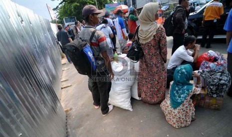 Penumpang menunggu bus di taman Terminal Rawamangun, Jakarta, Senin (18/8).(Republika/ Wihdan)