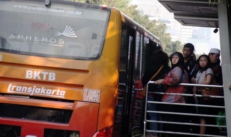 Penumpang menunggu Bus TransJakarta di Halte Bus Monumen Nasional, Jakarta Pusat, Jumat (20/6). 