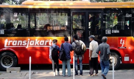 Penumpang menunggu Bus TransJakarta di Halte Bus Monumen Nasional, Jakarta Pusat, Jumat (20/6). 