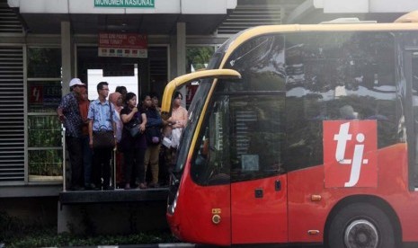 Penumpang menunggu Bus TransJakarta di Halte Bus Monumen Nasional, Jakarta Pusat, Jumat (20/6). 