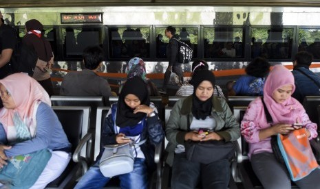 Penumpang menunggu kedatangan kereta di Stasiun Gambir, Jakarta, Sabtu (1/6/2019). 