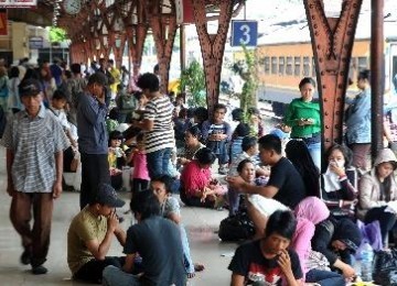 Penumpang menunggu kedatangan kereta di Stasiun Senen.