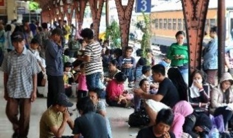 Penumpang menunggu kedatangan kereta di Stasiun Senen.