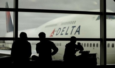 Penumpang menunggu pesawat di Bandara LaGuardia, New York. Badai Sandy membuat maskapai harus membatalkan total seluruh jadwal penerbangan sejak Ahad. Kini, maskapai AS, salah satunya Delta Air Lines, berupaya kembali membuka layanan.