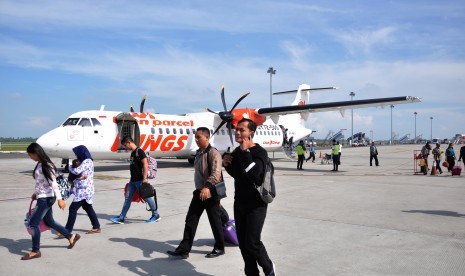 Penumpang pesawat udara berjalan menuju terminal kedatangan saat tiba di Bandara Internasional Kualanamu, Kabupaten Deli Serdang, Sumatera Utara, Senin (14/1).  Sejumlah maskapai penumpang telah menginformasikan pengajuan penerbangan tambahan untuk penerbangan kargo di sejumlah bandara AP II. 