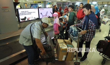 Penumpang pesawat udara mengemasi barang bagasi mereka setibanya di Bandara Internasional Minangkabau (BIM), Padangpariaman, Sumatra Barat, Kamis (7/6). 