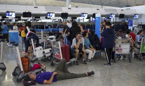 Penumpang telantar di terminal keberangkatan di Bandara Internasional Hong Kong di Hong Kong, Selasa (13/8). 