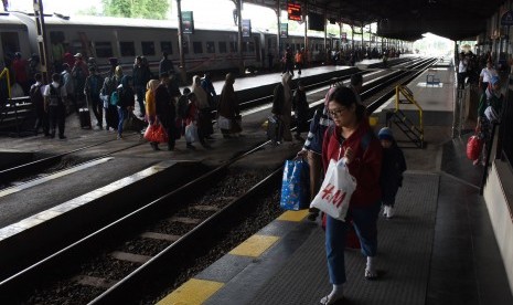 Penumpang turun dari Kereta Api (KA) di stasiun KA Madiun, Jawa Timur, Senin (24/12/2018). 