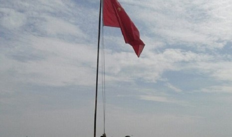 Penurunan bendera Cina oleh petugas keamanan PT Asri Gita Prasarana dan Babinsa KoramiL Mariana.