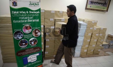 Petugas merapikan kotak kupon tanda bukti penerimaan zakat infaq sedekah. 