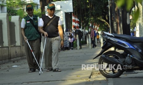 Penyandang disabilitas dari komunitas netra berjalan ditrotoar saat aksi pemantauan fasilitas akses penjalan kaki atau pedestrian untuk disabilitas di Kawasan Kebon Sirih, Jakarta, Rabu (30/8). 