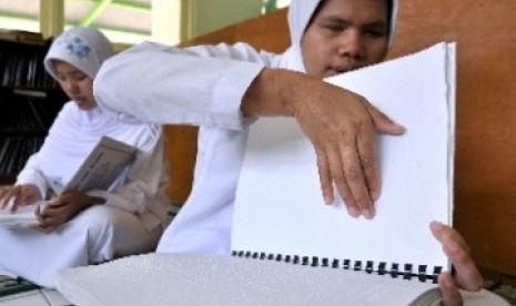 Penyandang tunanetra membaca Alquran braille.