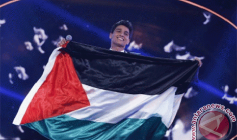 Penyanyi asal Palestina Mohamed Assaf membawa bendera negaranya, saat berdiri diatas panggung usai dinobatkan sebagai pemenang final 